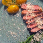 Grillet entrecote skjært i skiver, med poteter, aspargesbønner og revet parmesanost.