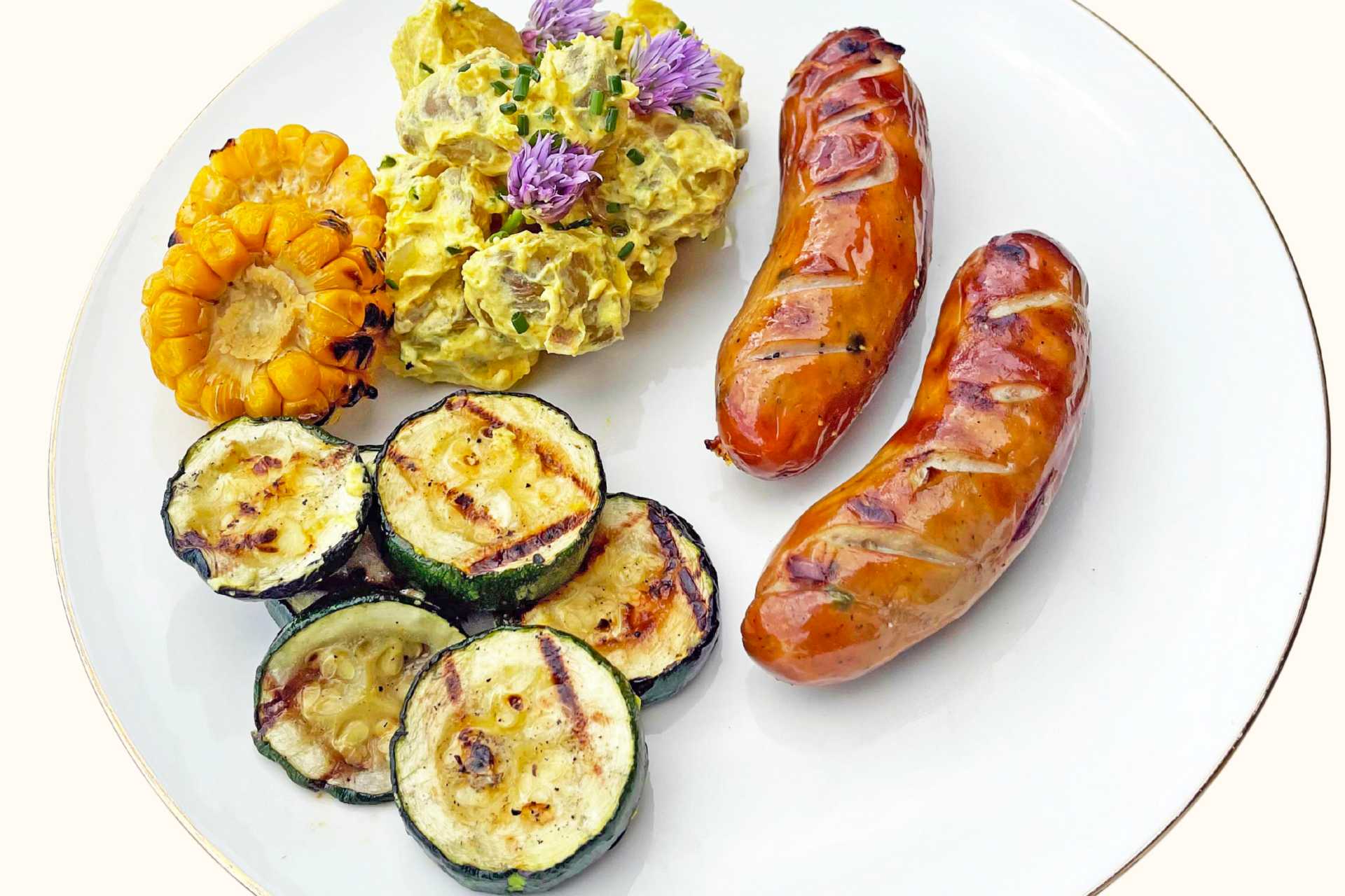 Pølser med curried potetsalat og grillede grønnsaker